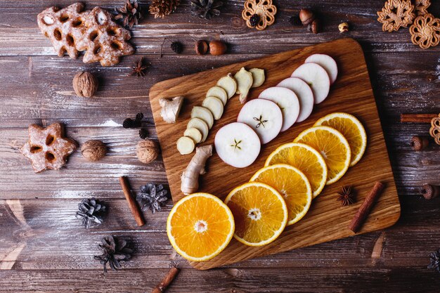 Glühwein kochen. Orangen, Äpfel und Arten liegen auf Holztisch