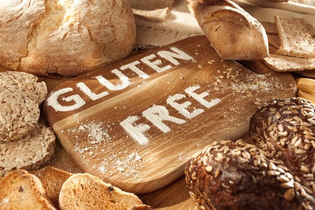 Glutenfreies Essen. Verschiedene Nudeln, Brot und Snacks auf hölzernem Hintergrund von oben. Gesundes und Diät-Konzept.