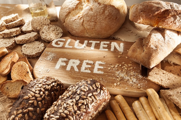 Glutenfreies Essen. Verschiedene Nudeln, Brot und Snacks auf hölzernem Hintergrund von oben