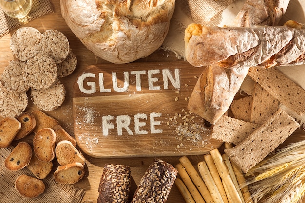 Glutenfreies Essen. Verschiedene Nudeln, Brot und Snacks auf hölzernem Hintergrund von oben