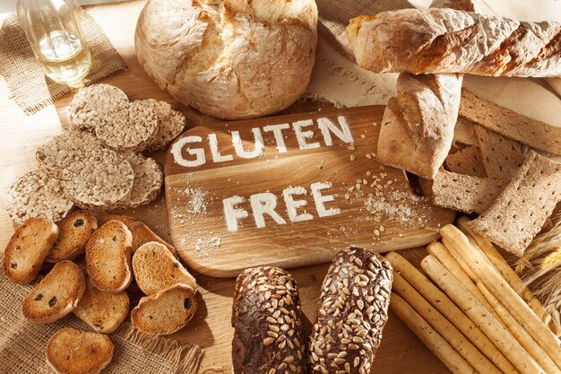 Glutenfreies Essen. Verschiedene Nudeln, Brot und Snacks auf Holz