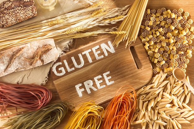 Glutenfreies Essen. Verschiedene Nudeln, Brot und Snacks auf Holz