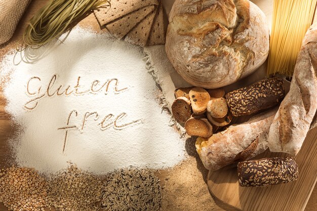 Glutenfreies Essen. Verschiedene Nudeln, Brot und Snacks auf Holz