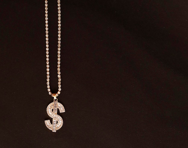 Kostenloses Foto gold-dollar-symbol auf goldener kette schmuck halskette hintergrund mit platz für textbanner modeaccessoires