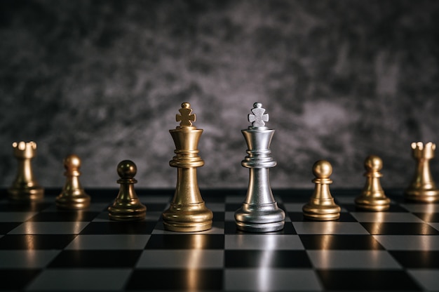 Gold- und Silberschach auf Schachbrettspiel für Geschäftsmetapherführungskonzept