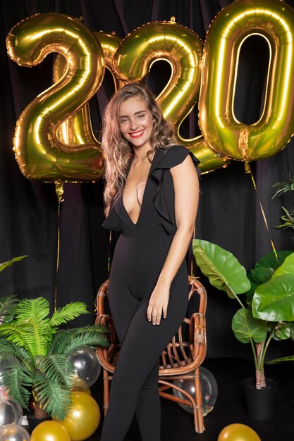 Goldene Ballone des neuen Jahres 2020 und schönes Mädchen
