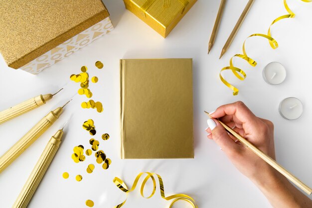 Goldene Elemente mit Notebook und Hand
