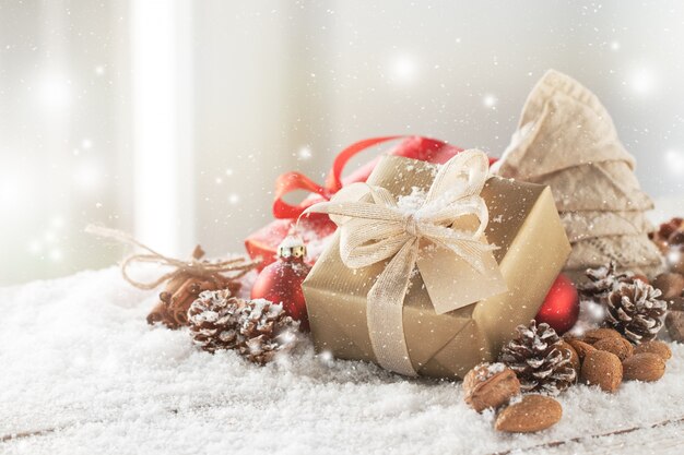 Goldene Geschenk mit weißen Bogen auf Weihnachtskugeln