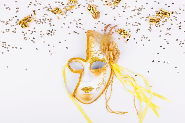 Goldener Konfetti-Rahmen und goldene Maske