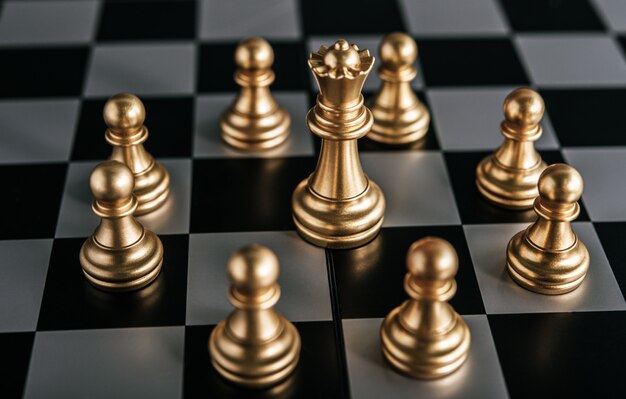Goldschach auf Schachbrettspiel für Geschäftsmetapher-Führungskonzept