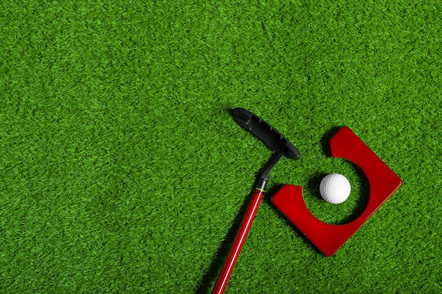 Golfball und Golfschläger auf Gras