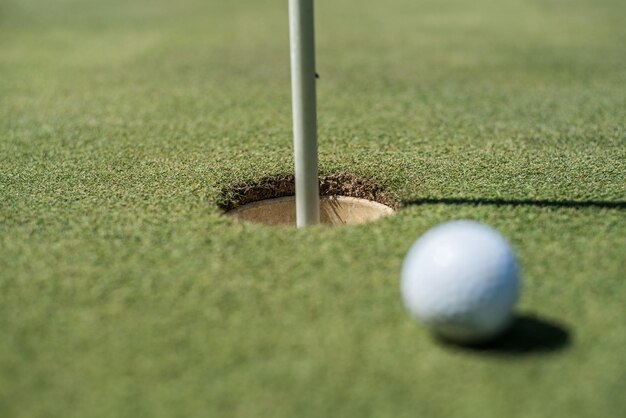 Golfplatz mit weißem Ball in der Nähe des Lochs