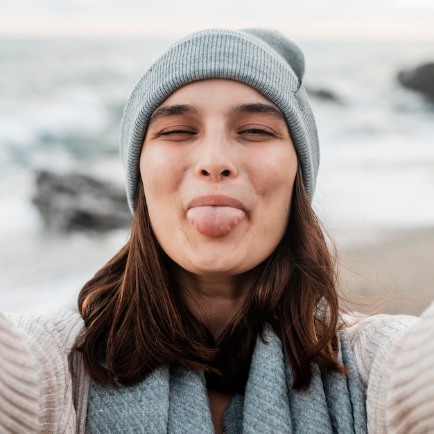 Kostenloses Foto goofy frau macht ein selfie am strand