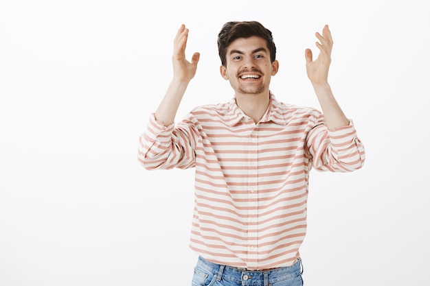 Gott sei Dank du hier. Porträt eines positiv freundlich aussehenden kaukasischen Mannes mit Bart und Schnurrbart, der die Handflächen hoch erhebt und breit lächelt und sich dem Freund dankbar fühlt