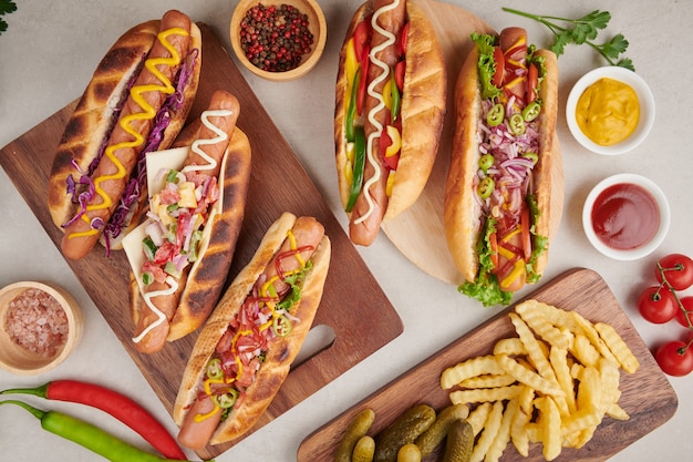 Gourmet gegrillt alle Rindfleisch Hot Dog mit Beilagen und Pommes. Leckere und einfache Hot Dogs mit Senf, Pfeffer, Zwiebeln und Nachos. Hot Dogs voll beladen mit verschiedenen Belägen auf einem Paddle Board.