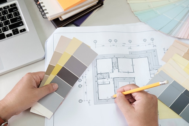 Grafikdesign und Farbmuster und Stifte auf einem Schreibtisch. Architektonische Zeichnung mit Werkzeugen und Zubehör.