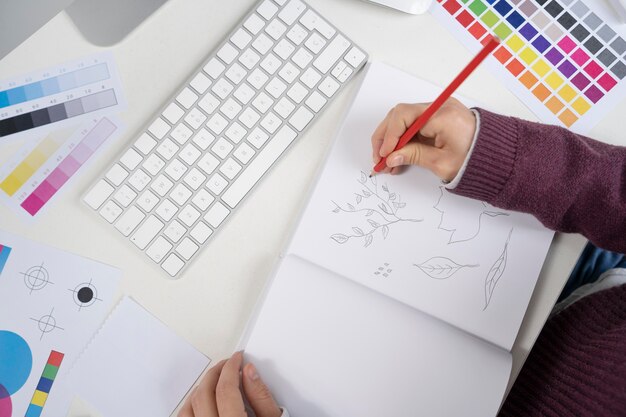 Grafikdesigner, der ein Logo auf einem Notizbuch macht