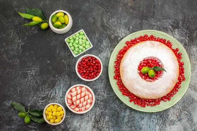 Granatapfelkuchen mit Granatapfelkernen Schalen mit Limetten verschiedene Süßigkeiten