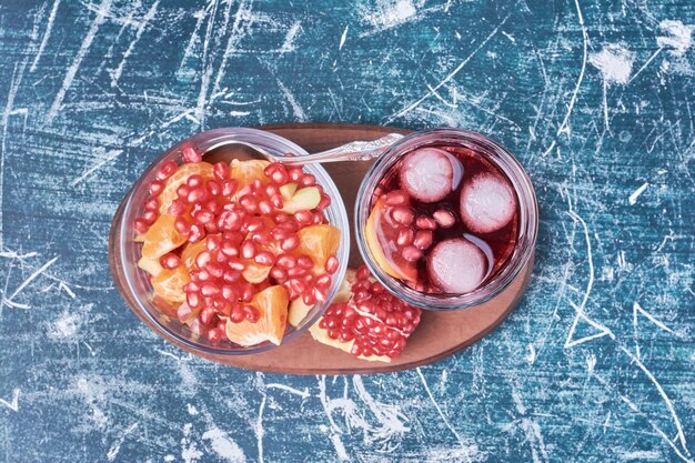 Granatapfelsalat und Saft auf blau.