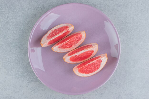 Grapefruitscheiben auf einer Platte auf Marmor