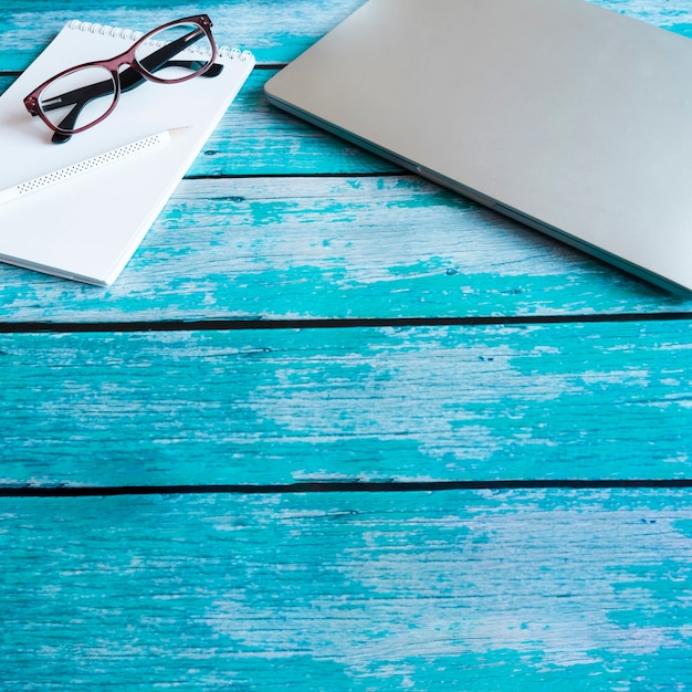 Grauer Laptop auf blauem Holztisch