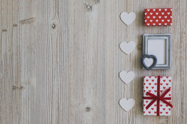 Grauer Rahmen mit zwei Geschenken und weißen Herzen