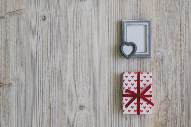 Kostenloses Foto grauer rahmen und polka dot geschenke auf einem holztisch