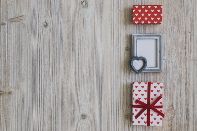 Grauer Rahmen und Polka Dot Geschenke auf einem Holztisch