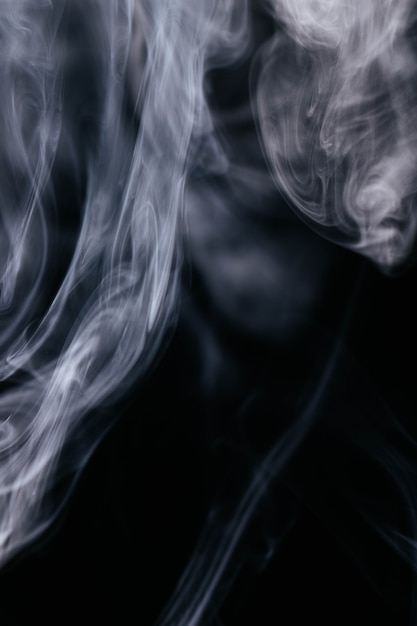 Grauer Rauch bewegt auf schwarzen Hintergrund wellenartig