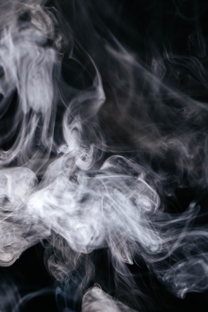 Grauer Rauch bewegt auf schwarzen Hintergrund wellenartig