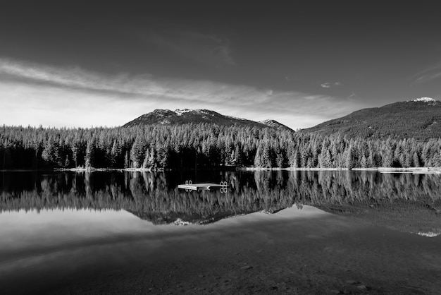 Graustufenaufnahme einer wunderschönen Landschaft, die sich im Lost Lake, Whistler, BC, Kanada, widerspiegelt?