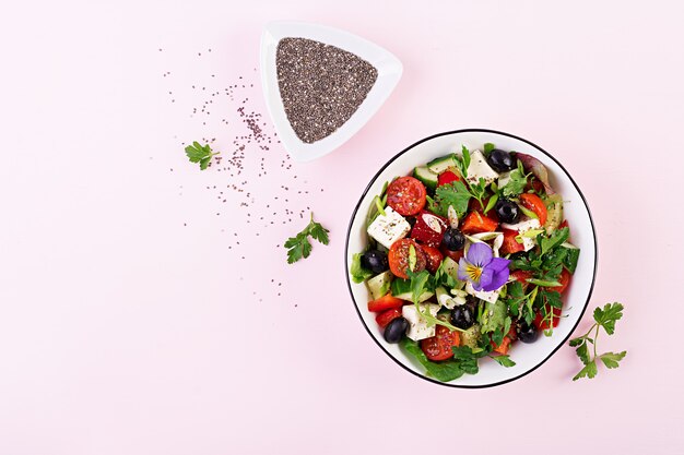 Griechischer Salat mit Gurke, Tomate, Paprika, Salat, Frühlingszwiebeln, Feta-Käse und Oliven mit Olivenöl. Gesundes Essen. Draufsicht