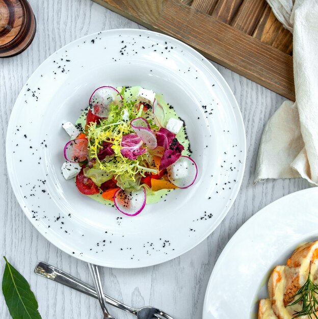 Griechischer Salat mit Radieschenscheiben dekoriert