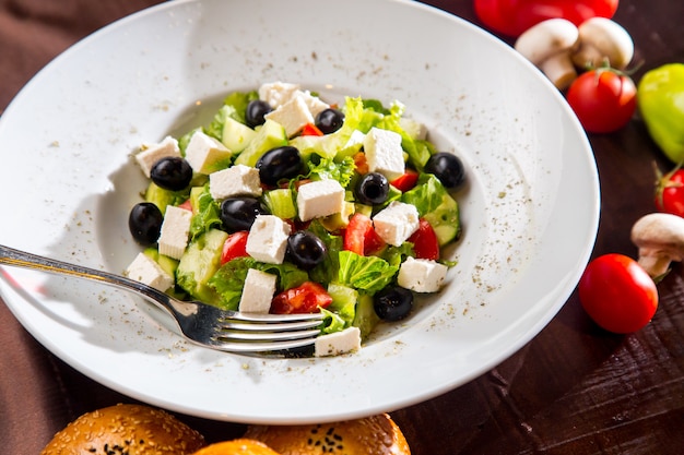 Griechischer Salat von oben mit schwarzem Olivenbrot und Pilzen