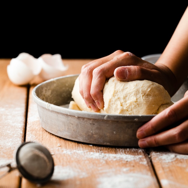 Großaufnahme einer Hand, die Teig macht