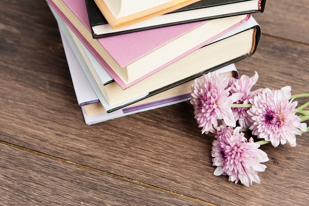 Großaufnahme von Büchern und von Blume auf Holztisch