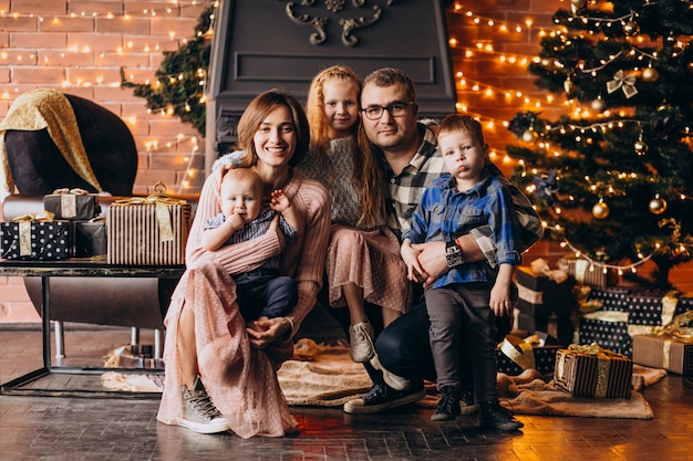 Große Familie am Heiligabend mit Geschenken durch Weihnachtsbaum