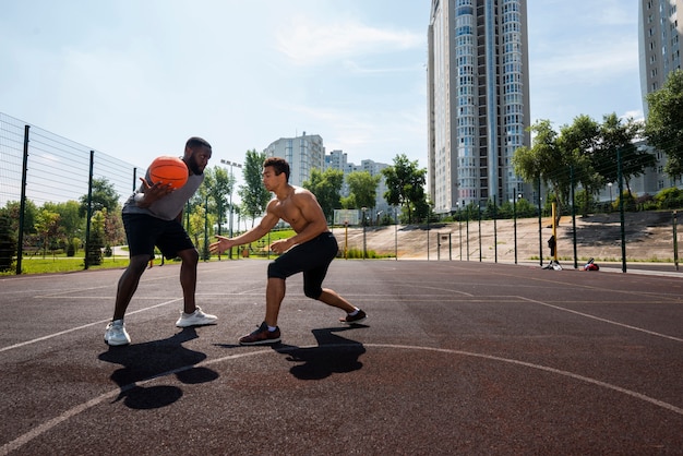 Große Männer, die auf städtischem Basketball spielen