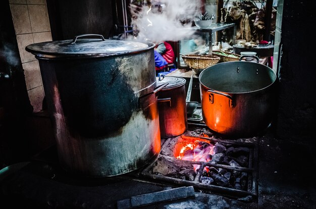 Große Metalltöpfe auf brennenden Kohlen in Hanoi