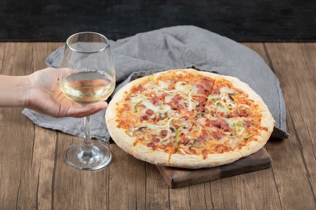 Große Portion Margarita-Pizza mit einem Glas Weißwein herum