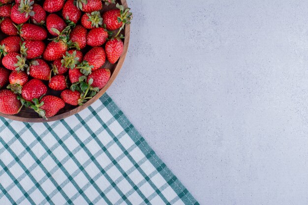 Große Schüssel voller Erdbeeren auf Marmorhintergrund. Foto in hoher Qualität