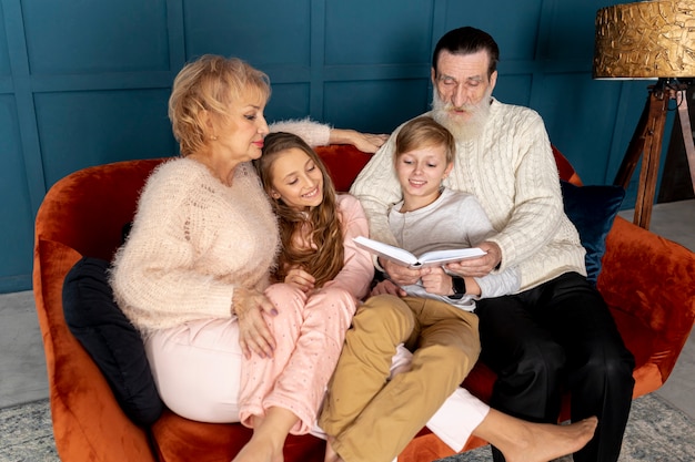 Großeltern, die mit ihren enkelkindern ein buch lesen