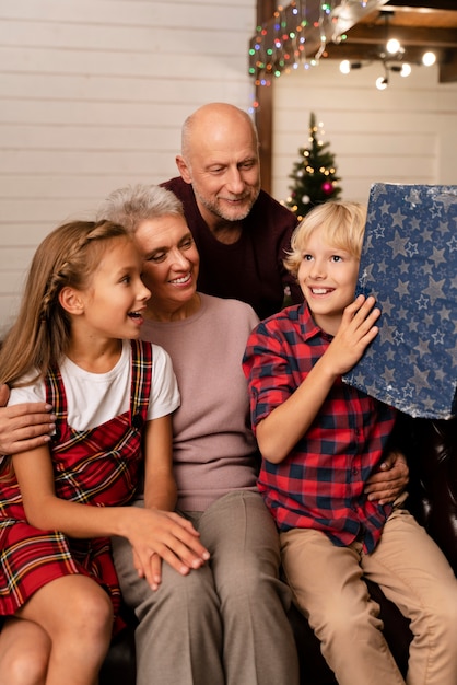 Großeltern und Kinder beim Öffnen von Geschenken hautnah