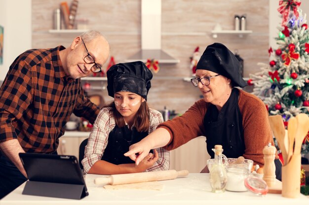 Großeltern und Nichte suchen Rezept zu Weihnachten