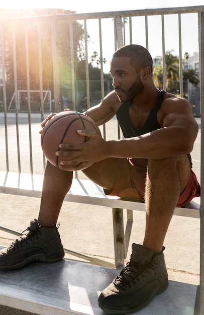 Kostenloses Foto großer mann macht eine pause vom basketball