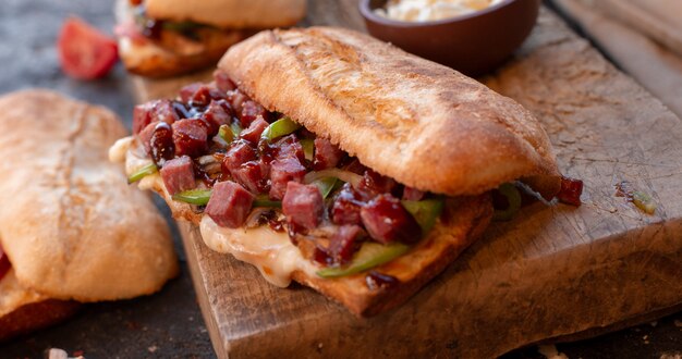 Großes Portionsstangenbrotsandwich voll der Mischwürste und des Gemüses