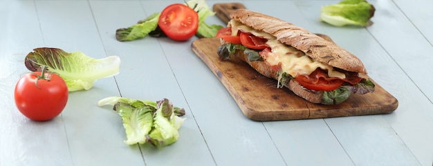 Kostenloses Foto großes veganes sandwich mit gemüse auf holzbretttisch