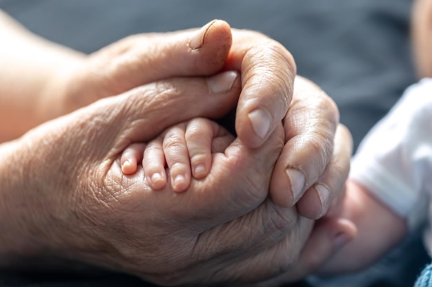 Kostenloses Foto großmutter hält die hand des babys in großaufnahme