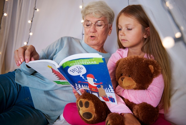 Großmutter liest ihrer Enkelin ein Buch vor