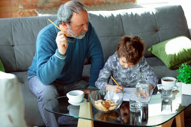 Großvater und sein Enkel verbringen Zeit isoliert zu Hause und studieren